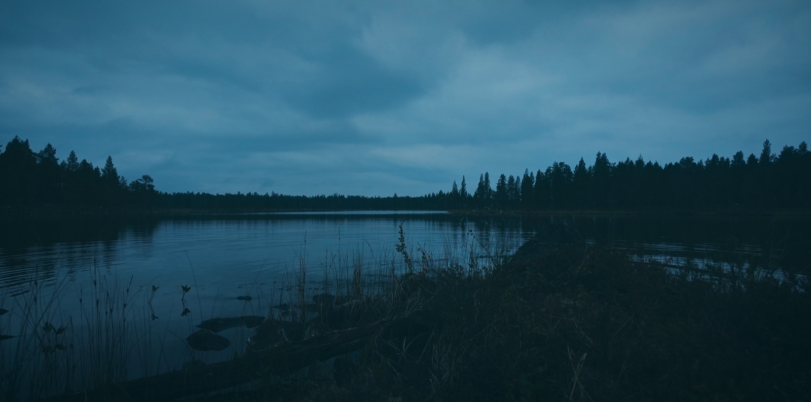 Tyyni erämaajärvi sinisessä illan valossa Vätsärin erämaassa Lapissa
